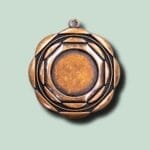 Rund bronzevedhæng på grøn baggrund.