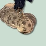 Guldsportsmedaljer med fodboldmotiv og sort bånd
