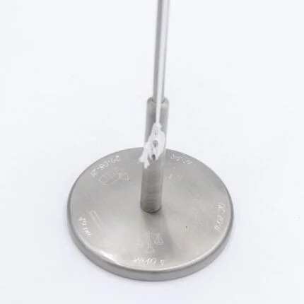 Metalstang med graveringer og snor.