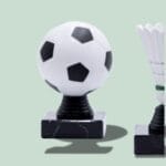 Fodbold og badminton pokaler på grøn baggrund