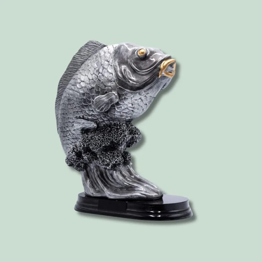 Metalfiskeskulptur på sort sokkel