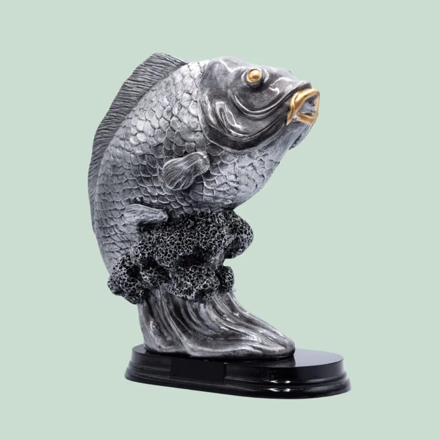 Sølvrød fiske statue med sorte detaljer