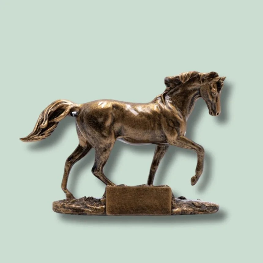 Bronzestatue af hest på grøn baggrund.