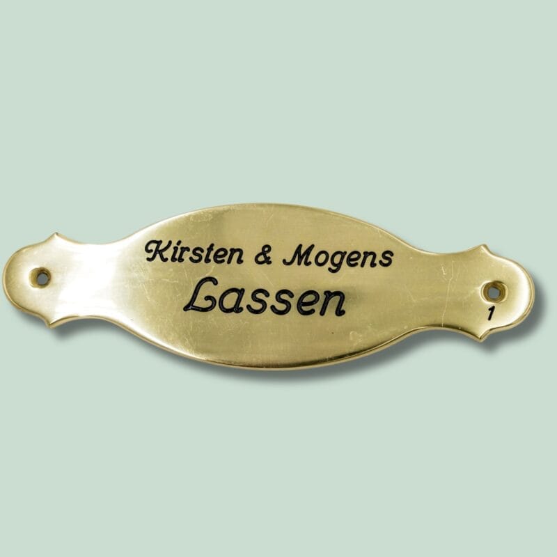 Messingdørskilt med navnene Kirsten og Mogens Lassen.
