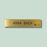 Gul dørskilt med tekst 'Anna Bach Nr. 14'.