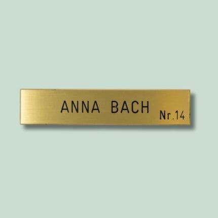 Gul dørskilt med tekst 'Anna Bach Nr. 14'.