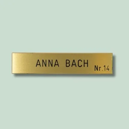 Gul dørskilt med tekst 'Anna Bach Nr. 14'.