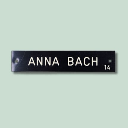 Navneskilt med tekst 'Anna Bach' og tallet 14.