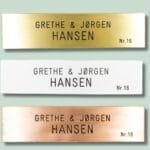Tre navneskilte i forskellige farver og materialer.