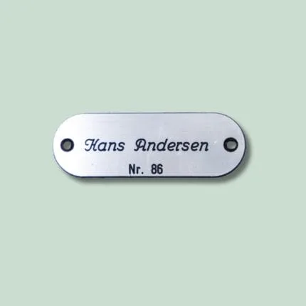 Navneskilt med navn og nummer, oval form.