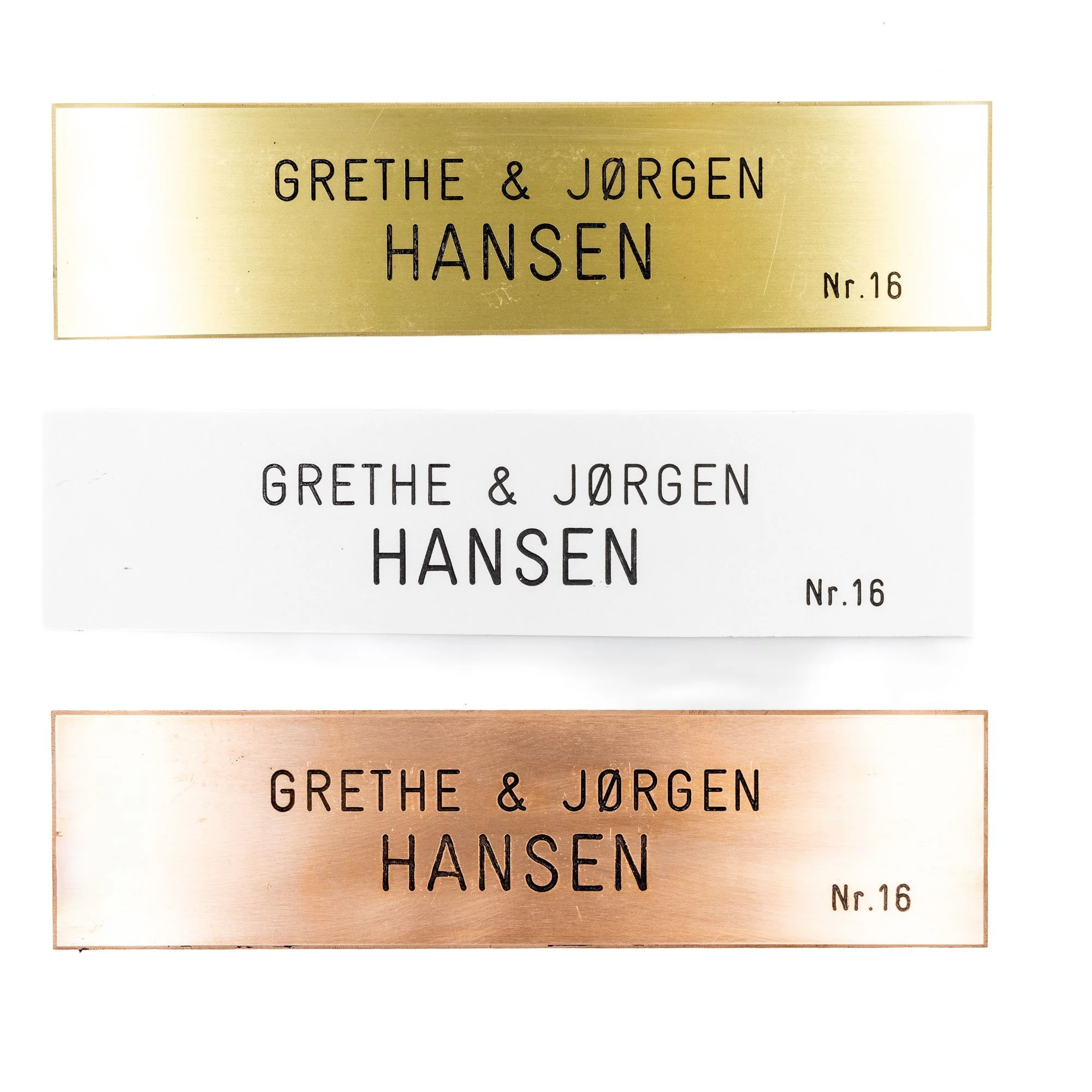 Tre navneskilte i forskellige materialer.