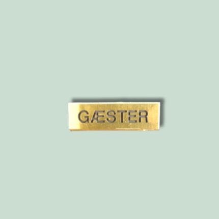 Guld skilt med teksten 'GÆSTER' på grøn baggrund.