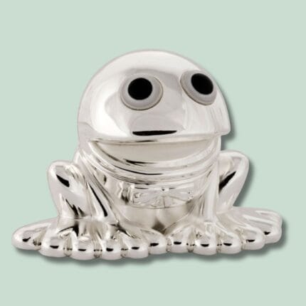 Sølvfrø figur med store øjne på mint baggrund.