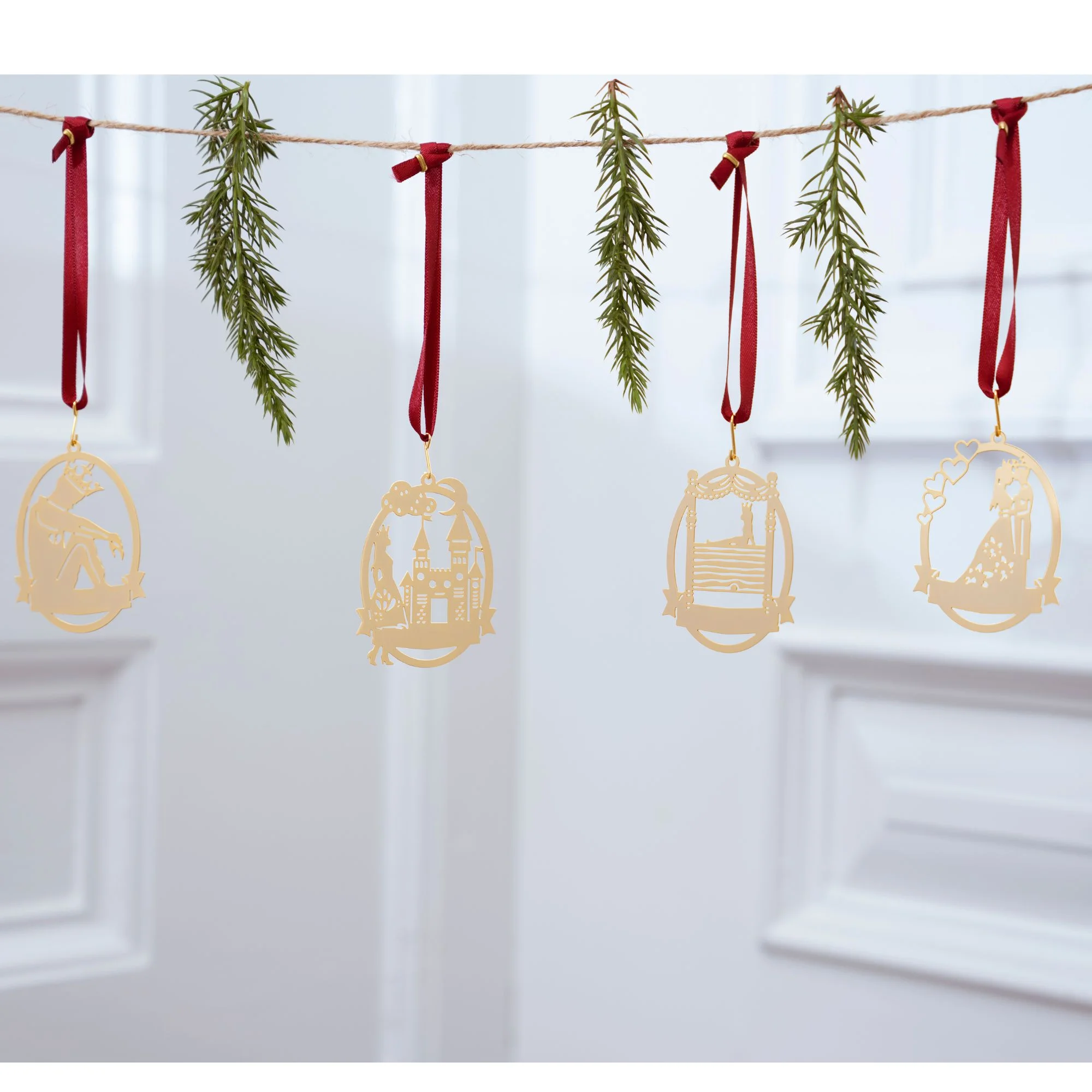 Gyldne julepynt på snor med grene