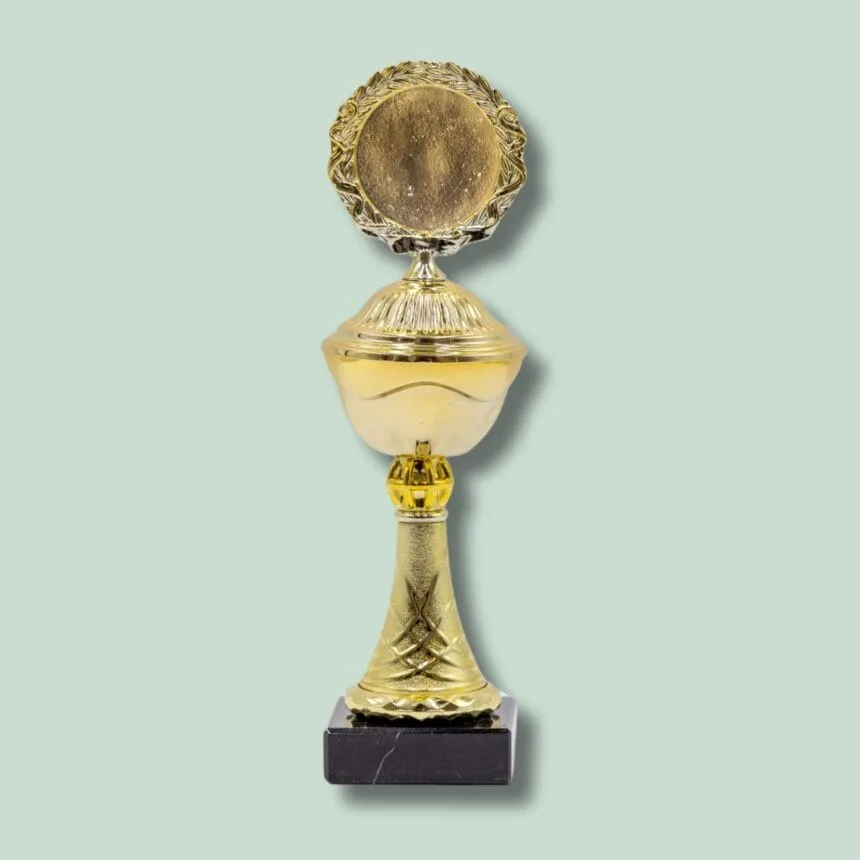 Guldpokal på mørk sokkel mod lys baggrund.