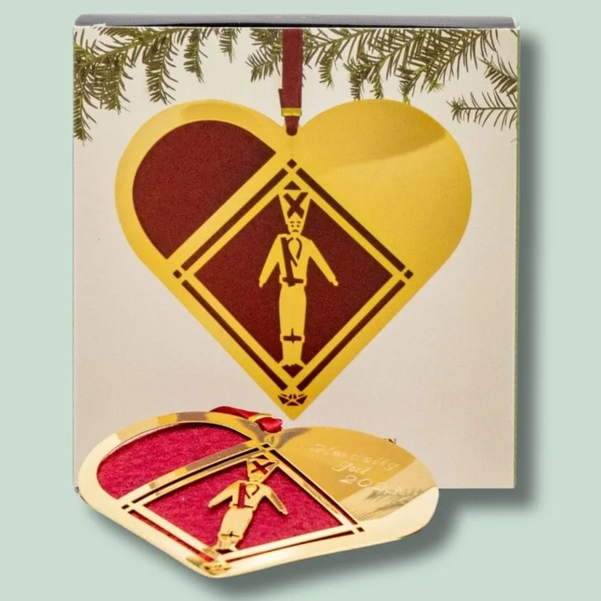 Guld julehjerte ornament med garder motiv.