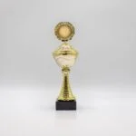 Guldpokal med rund medalje på sort marmorfod