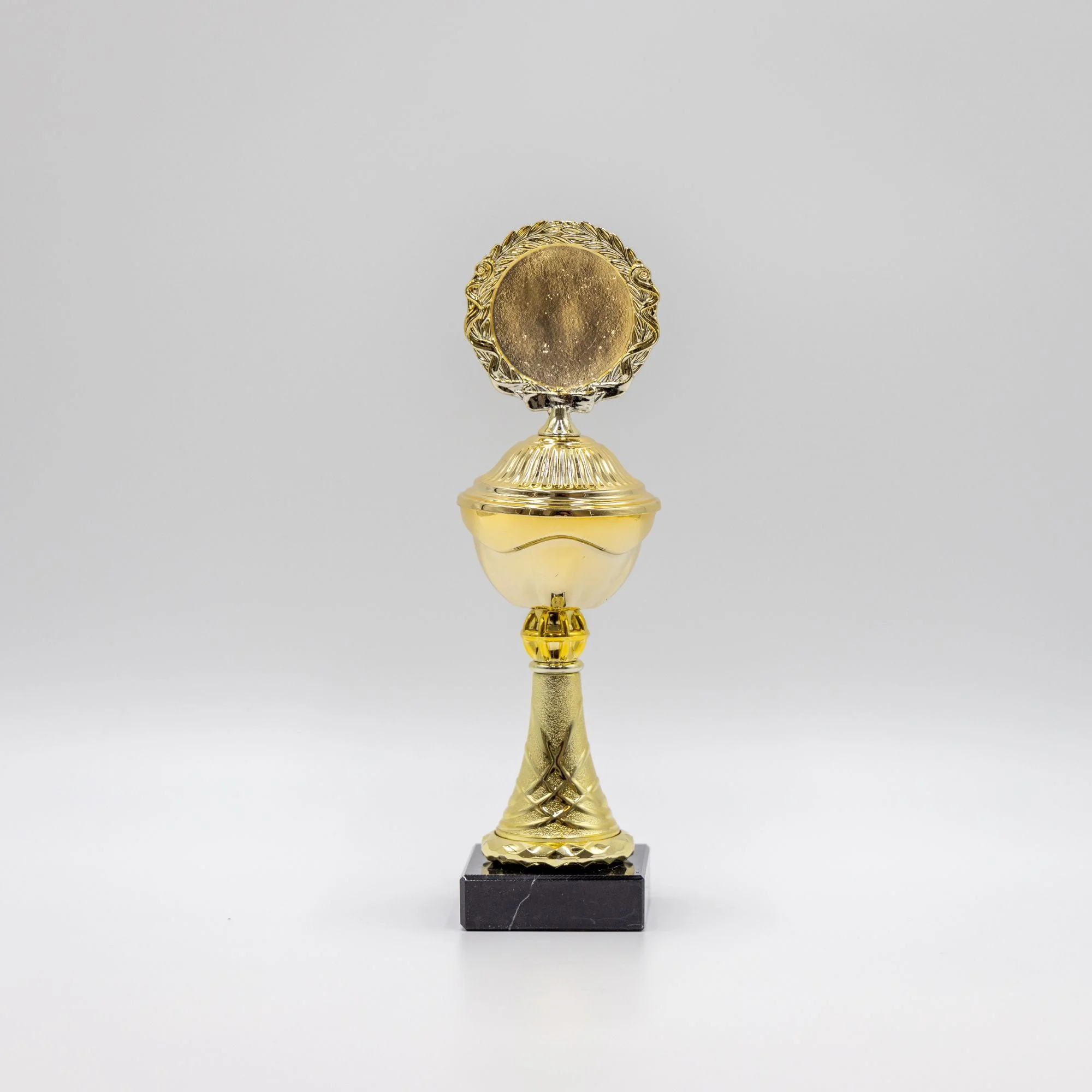 Guldfarvet pokal med rund medalje på sort fod