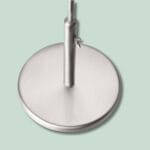 Stålbase til lampe på mintgrøn baggrund.
