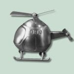 Metallisk modelhelikopter mod lys grøn baggrund.
