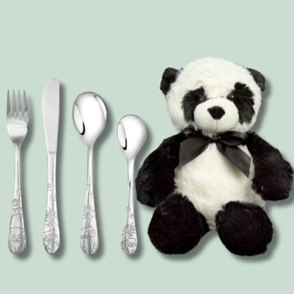 Bestik og plys-panda på grøn baggrund