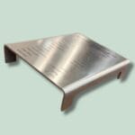 Metalplade med indgraveret tekst og bøjet design.
