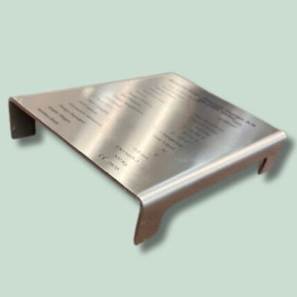 Metalplade med indgraveret tekst og bøjet design.