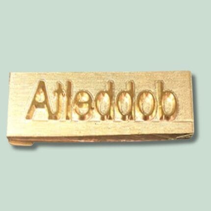 Guldblok med indgraveret tekst 'Atleddob'.