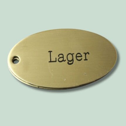 Messingnøgleskilt med indgraveret tekst "Lager