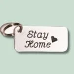 Nøglering med metalmærke indgraveret “Stay Home” og hjerte