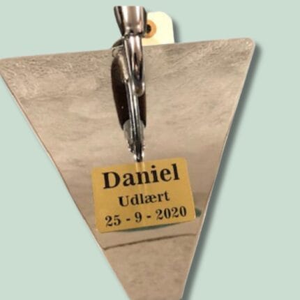 Udlært plakat med navn og dato, trekantet form.