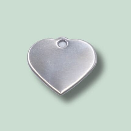 Hjerteformet metalcharm med hul i toppen.