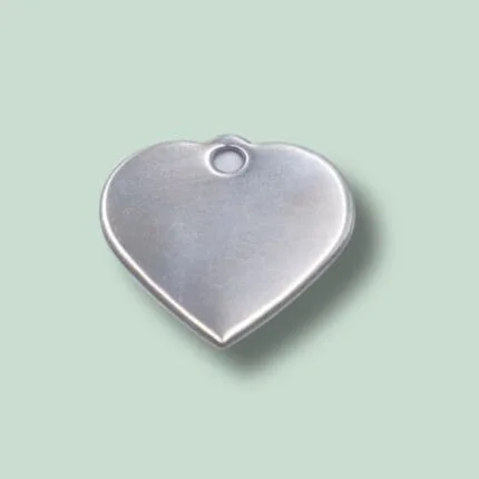 Hjerteformet metalcharm med hul i toppen.