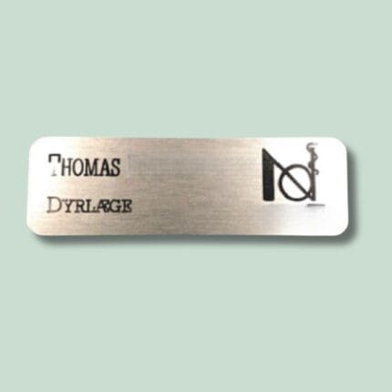 Metalnavneskilt med teksten Thomas Dyrlæge og monogram