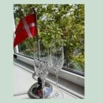 To champagneglas og dansk flag ved vindue