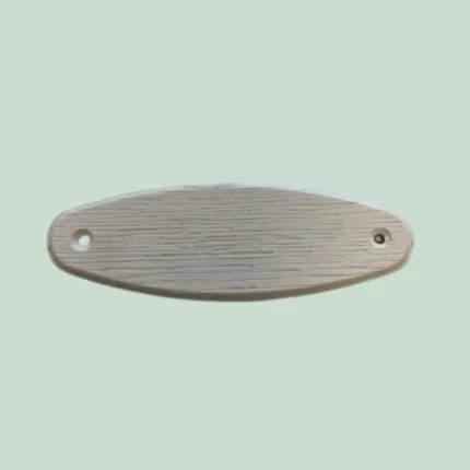 Oval, hvid metaldel med huller