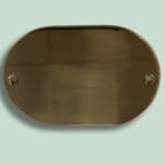 Oval brun metalplade med huller til montering.