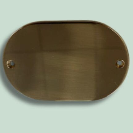 Oval brun metalplade med huller til montering.