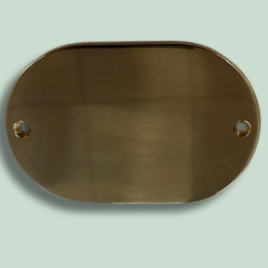 Oval brun metalplade med huller til montering.