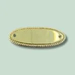 Oval, gylden metalplade med dekorative kanter.