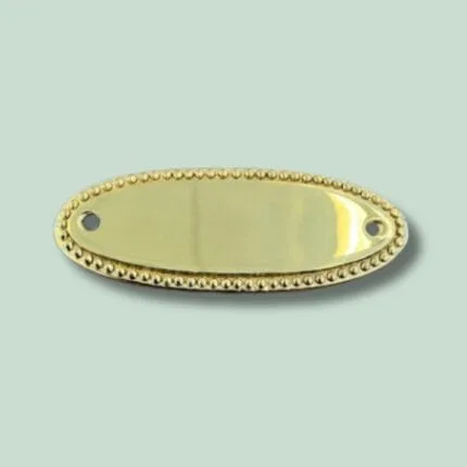 Oval, gylden metalplade med dekorative kanter.