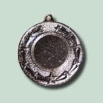 Rund sølvfarvet medalje med stjernemønster og ophængningsøje