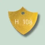 Gul metalskilt med inskriptionen H 108.