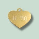Guld hjerteformet vedhæng med indgravering H 110.