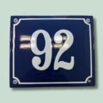 Blå husnummerplade med nummer 92.