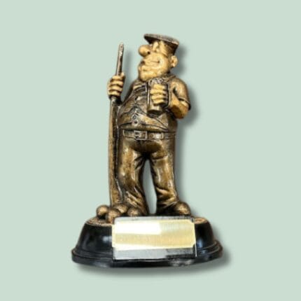 Bronze karikaturfigur med kost og bryggerhat.