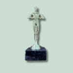 Sølvfarvet statuette på sort marmorsokkel.