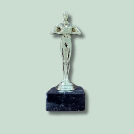 Sølvfarvet statuette på sort marmorsokkel.