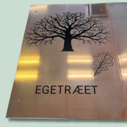 Kobberskilt med egetræ og ordet 'Egetræet' på dansk.
