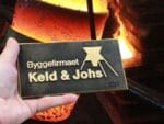 Logo for byggefirma foran smeltet metal.